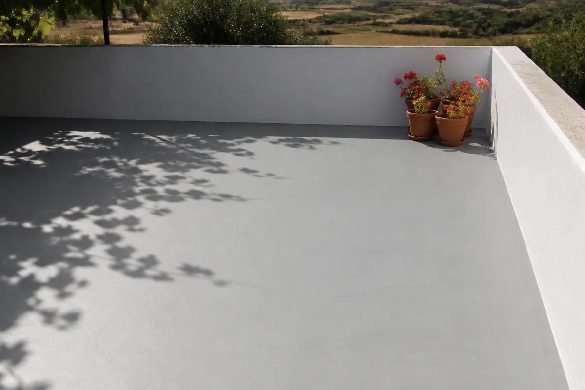 Terraza de una casa extremeña con el suelo recién impermeabilizado en gris claro